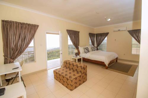 AburiにあるBrown Hills Residencesのベッドルーム1室(ベッド1台、椅子、窓付)