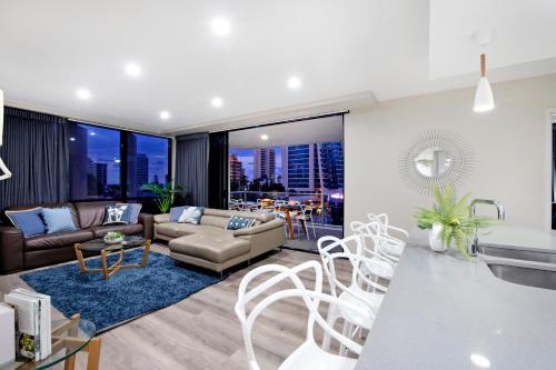 a living room with a couch and a table at Circle on Cavill Surfers Paradise- 3 Bedroom SPA Apartment in Gold Coast
