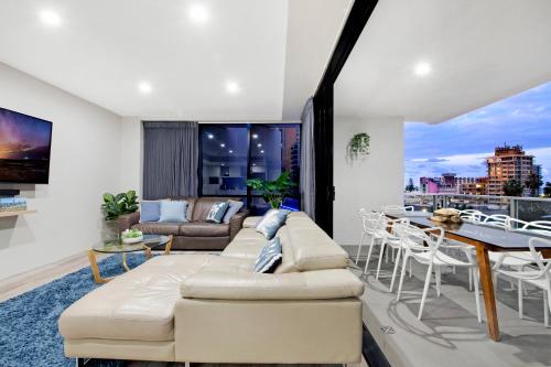 a living room with a couch and a table at Circle on Cavill Surfers Paradise- 3 Bedroom SPA Apartment in Gold Coast