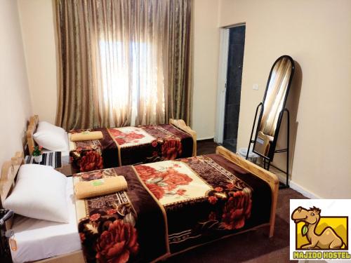 a hotel room with two beds and a window at Majido Hotel in Wadi Musa