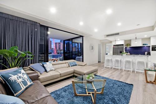 a living room with a couch and a table at Circle on Cavill Surfers Paradise- 3 Bedroom SPA Apartment in Gold Coast