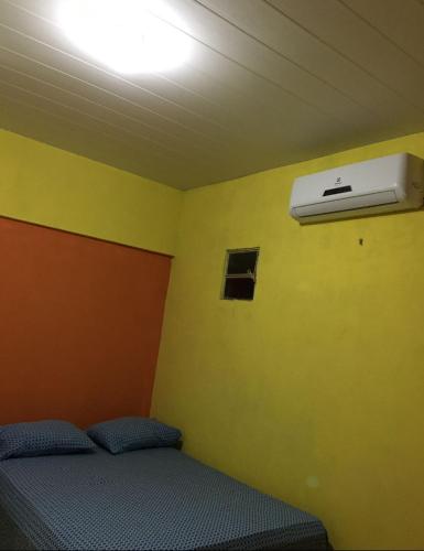 a room with a bed and a air conditioner at Lençóis Hospedagens in Barreirinhas