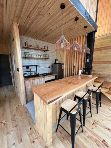 a kitchen with a large wooden table and chairs at Tripanko Lodge & Bungalows in Pichilemu