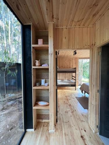 a tiny house with a large glass door at Tripanko Lodge & Bungalows in Pichilemu