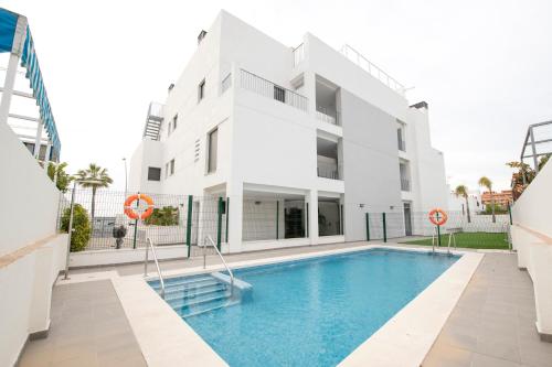 a building with a swimming pool in front of a building at Arenas de Sanlúcar in Sanlúcar de Barrameda