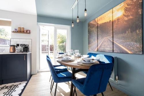 a dining room with a table and blue chairs at Railway House - Central Warrington - Sleeps 6 in Warrington