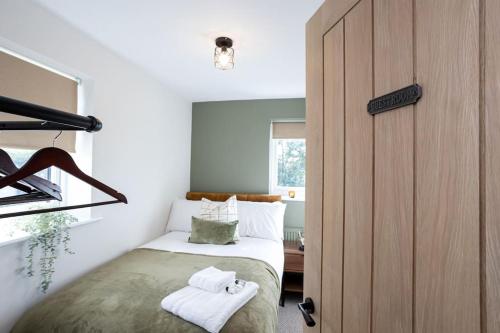 een slaapkamer met een bed met handdoeken erop bij Stylish Railway Themed House - Central Warrington in Warrington