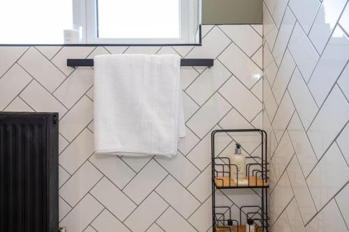 a bathroom with a white towel and a towel rack at Stylish Railway Themed House - Central Warrington in Warrington