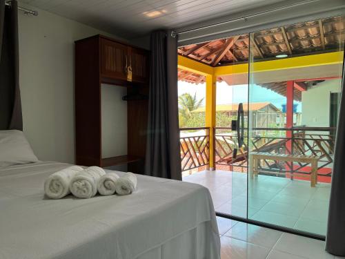 a bedroom with a bed with three towels on it at Pousada Solar Maia Costa in Atins