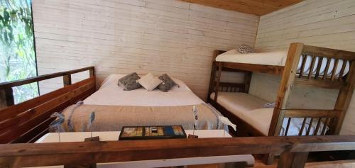 a bedroom with two bunk beds and a desk at Tripanko Lodge & Bungalows in Pichilemu