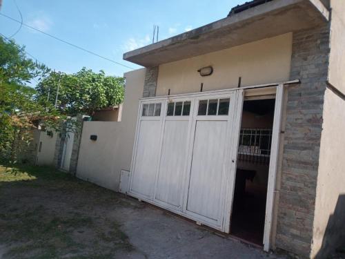 un garaje con una puerta blanca al lado de un edificio en Casa Santa Teresita en Santa Teresita