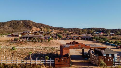 a village in the middle of a hill with houses at Entrevalle Hotel Boutique in Valle de Guadalupe