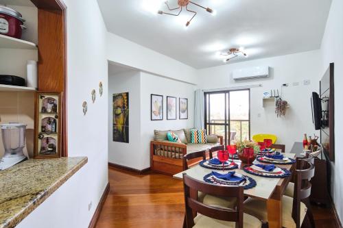 a dining room and living room with a table and chairs at Charmoso apto a 200 m da rua mais turistica da cidade c Wifi e garagem in Ubatuba