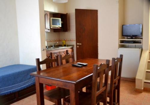 eine Küche mit einem Holztisch und Stühlen sowie ein Esszimmer in der Unterkunft Cabañas Terrazas Chascomús in Chascomús