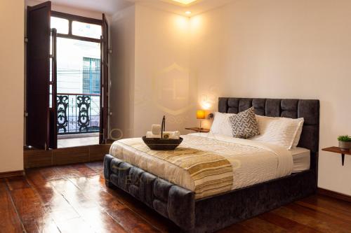 a bedroom with a large bed and a window at Suites Experience by Hotel David in Quito