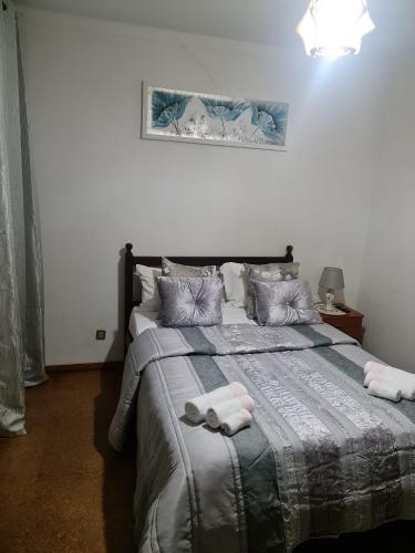 a bedroom with a bed with a towel on it at Alojamento Local Largo da Igreja in Santiago do Cacém