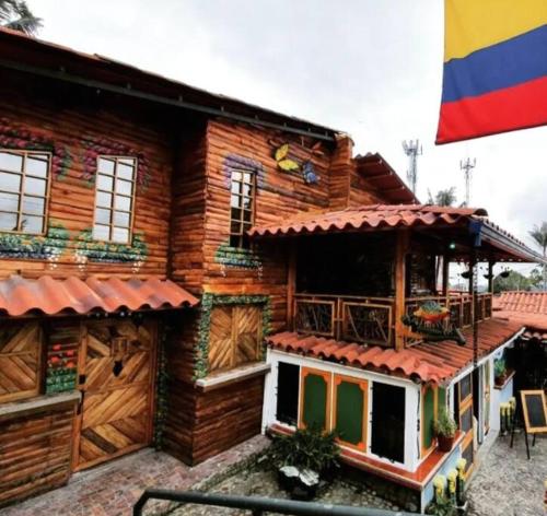 a wooden house with a flag in front of it at El Encanto Mountain Cabin in Salento