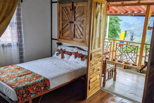 ein Schlafzimmer mit einem Bett und einem Balkon in der Unterkunft El Encanto Mountain Cabin in Salento