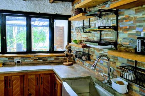 a kitchen with a sink and some windows at El Encanto Mountain Cabin in Salento
