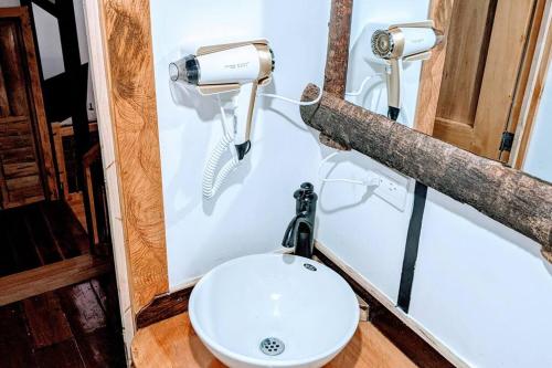 La salle de bains est pourvue de toilettes blanches. dans l'établissement El Encanto Mountain Cabin, à Salento