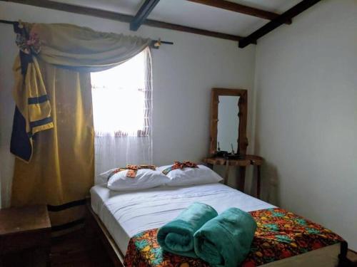 a small bedroom with a bed with a window at El Encanto Mountain Cabin in Salento