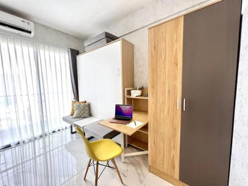 a small office with a yellow chair and a desk with a laptop at DayInn, Skyhouse BSD Lux and Homey Studio, near AEON BSD and ICE BSD in Cilenggang