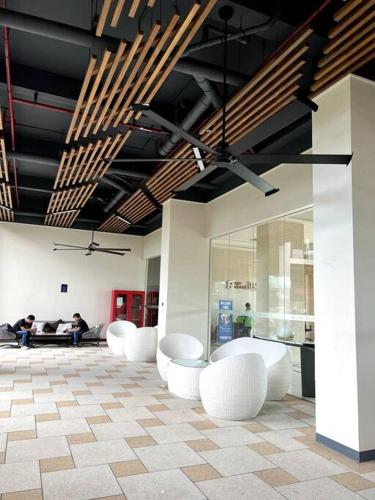 a group of white chairs in a room with people at DayInn, Skyhouse BSD Lux and Homey Studio, near AEON BSD and ICE BSD in Cilenggang