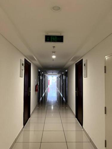 a hallway in a building with a clock on the ceiling at DayInn, Skyhouse BSD Lux and Homey Studio, near AEON BSD and ICE BSD in Cilenggang