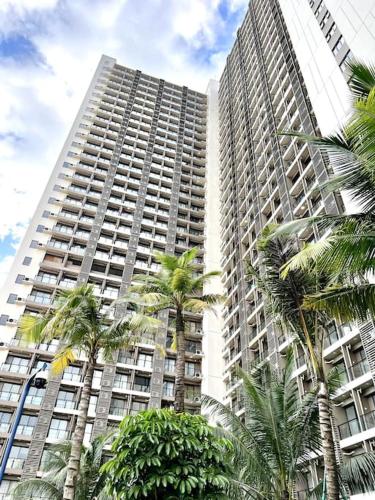 a tall building with palm trees in front of it at DayInn, Skyhouse BSD Lux and Homey Studio, near AEON BSD and ICE BSD in Cilenggang