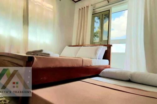 1 dormitorio con cama y ventana en Mireya's 1BR condo at Zone Vill - Burnham Park, en Baguio
