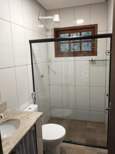 ein Bad mit einer Dusche, einem WC und einem Waschbecken in der Unterkunft Casa Colmeia in Lençóis