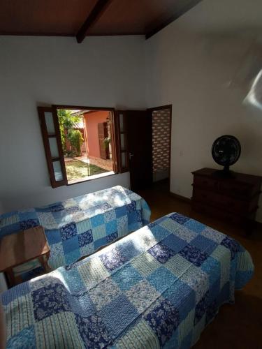 a bedroom with two beds and a window at Casa Colmeia in Lençóis