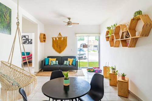 a living room with a black table and chairs at Nest to rest - Cozy ground floor apt with 2 bedrooms, pool and facilities in Puerto Morelos