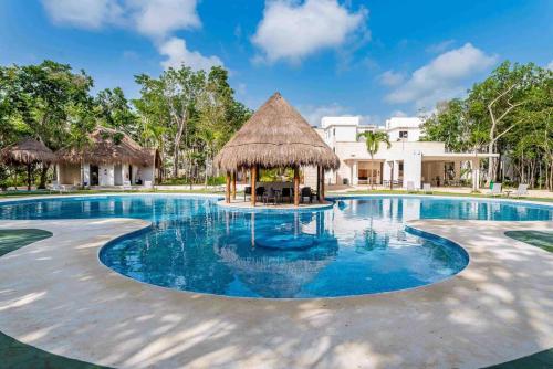 a swimming pool with a gazebo in a resort at Nest to rest - Cozy ground floor apt with 2 bedrooms, pool and facilities in Puerto Morelos