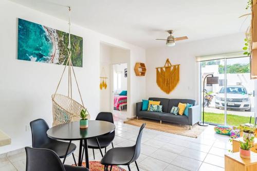 a living room with a table and chairs and a couch at Nest to rest - Cozy ground floor apt with 2 bedrooms, pool and facilities in Puerto Morelos