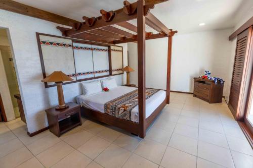 a bedroom with a canopy bed and a night stand at Villa Vanua - Private Luxury Villa in Rakiraki