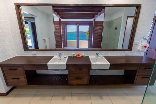 a bathroom with two sinks and a large mirror at Villa Vanua - Private Luxury Villa in Rakiraki