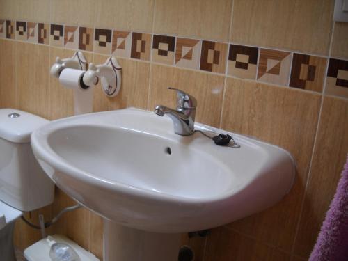 a bathroom with a white sink and a toilet at Casa Caremy in Almería