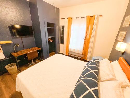 a bedroom with a bed and a desk and a window at ITH San Diego Mission Beach Backpacker Hostel in San Diego