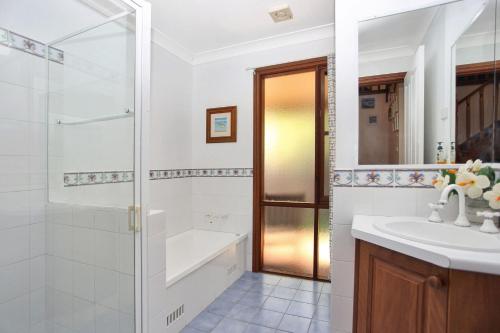 a bathroom with a shower and a sink at Semaphore Beach House in Hawks Nest