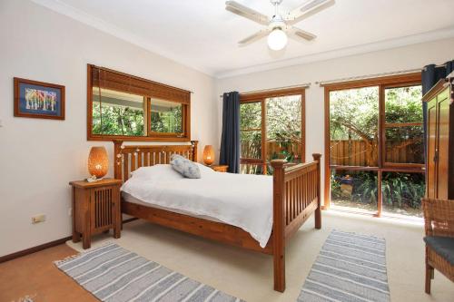 Schlafzimmer mit einem Bett und einem Deckenventilator in der Unterkunft Semaphore Beach House in Hawks Nest