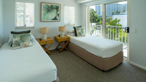 two beds in a bedroom with a balcony at Waters Edge Apartment Cairns in Cairns