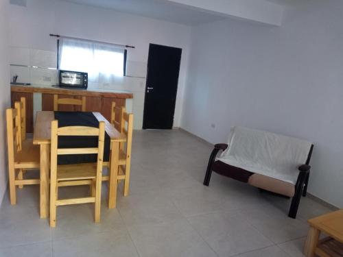 Habitación con mesa, sillas y cama en departamento a 6 cuadras del mar en Mar del tuyu en 