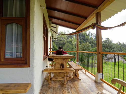 porche con mesa y bancos en el balcón en Rancho Santa Inés Completo, en Monguí