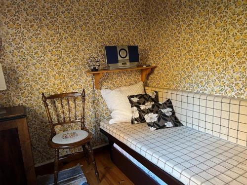 Cette petite chambre comprend un lit et une chaise. dans l'établissement Holiday home Hillerstorp, à Hillerstorp