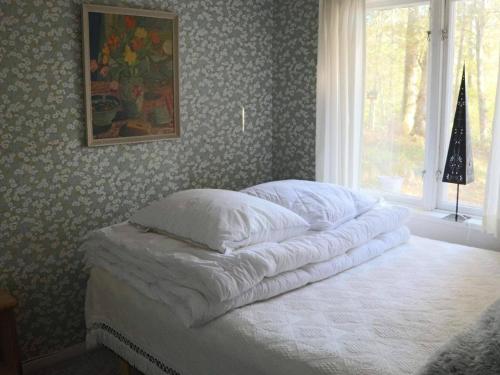 a bedroom with a bed with white sheets and a window at 4 person holiday home in SKÅNES-FAGERHULT-By Traum in Slättsjö