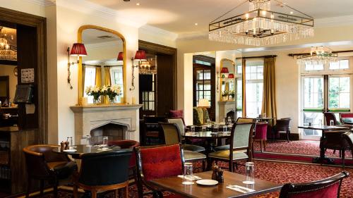 a restaurant with tables and chairs and a fireplace at The Keadeen Hotel in Newbridge