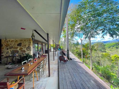 a building with tables and chairs on a deck with a view at Golden Retreat Ultimate 5 Bed - Villa & Guesthouse in Uki