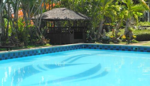 a swimming pool with a gazebo in a resort at Casa Las Brisas, Puerto Azul in Ternate