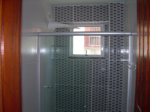 a bathroom with a shower with a window at Brisa Brasil Residence in Fortaleza